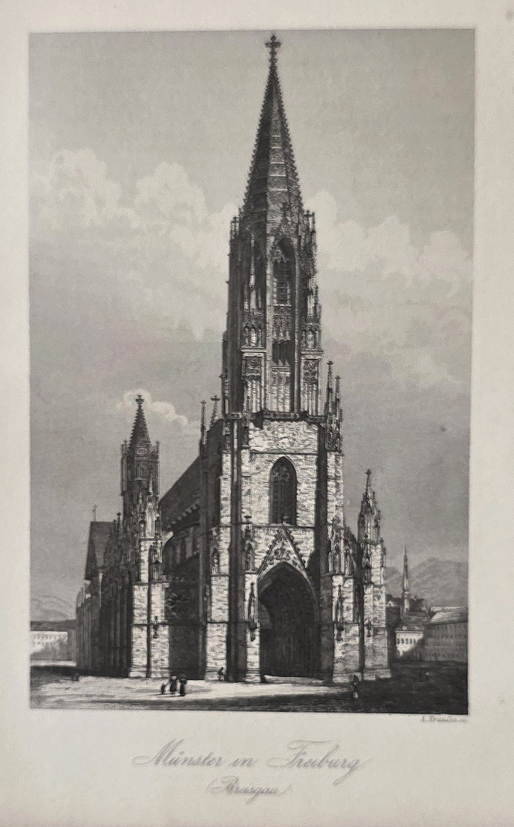 Schlanker Kirchturm über Stadtstraße