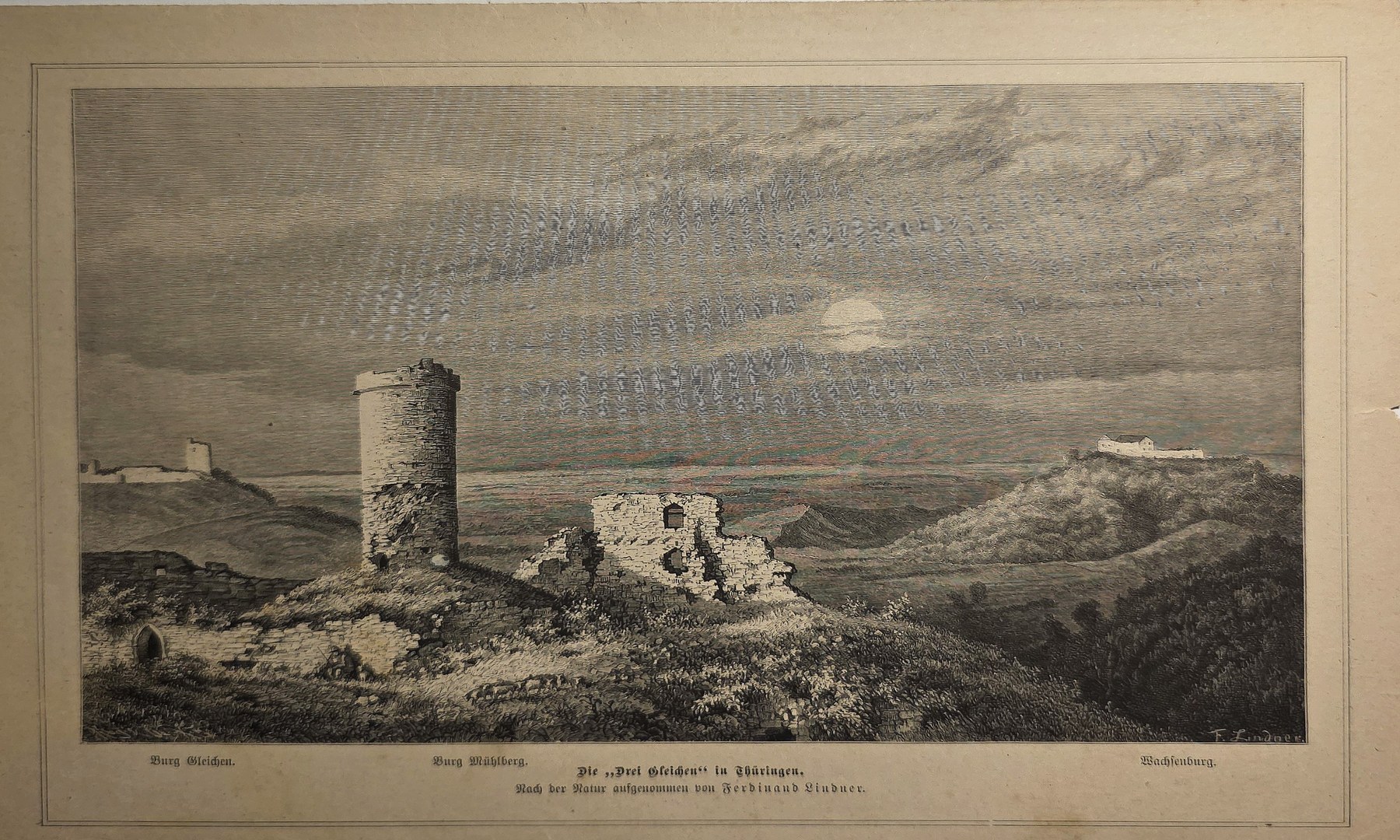 Runder Turm und Ruinen in weiter Hügellandschaft