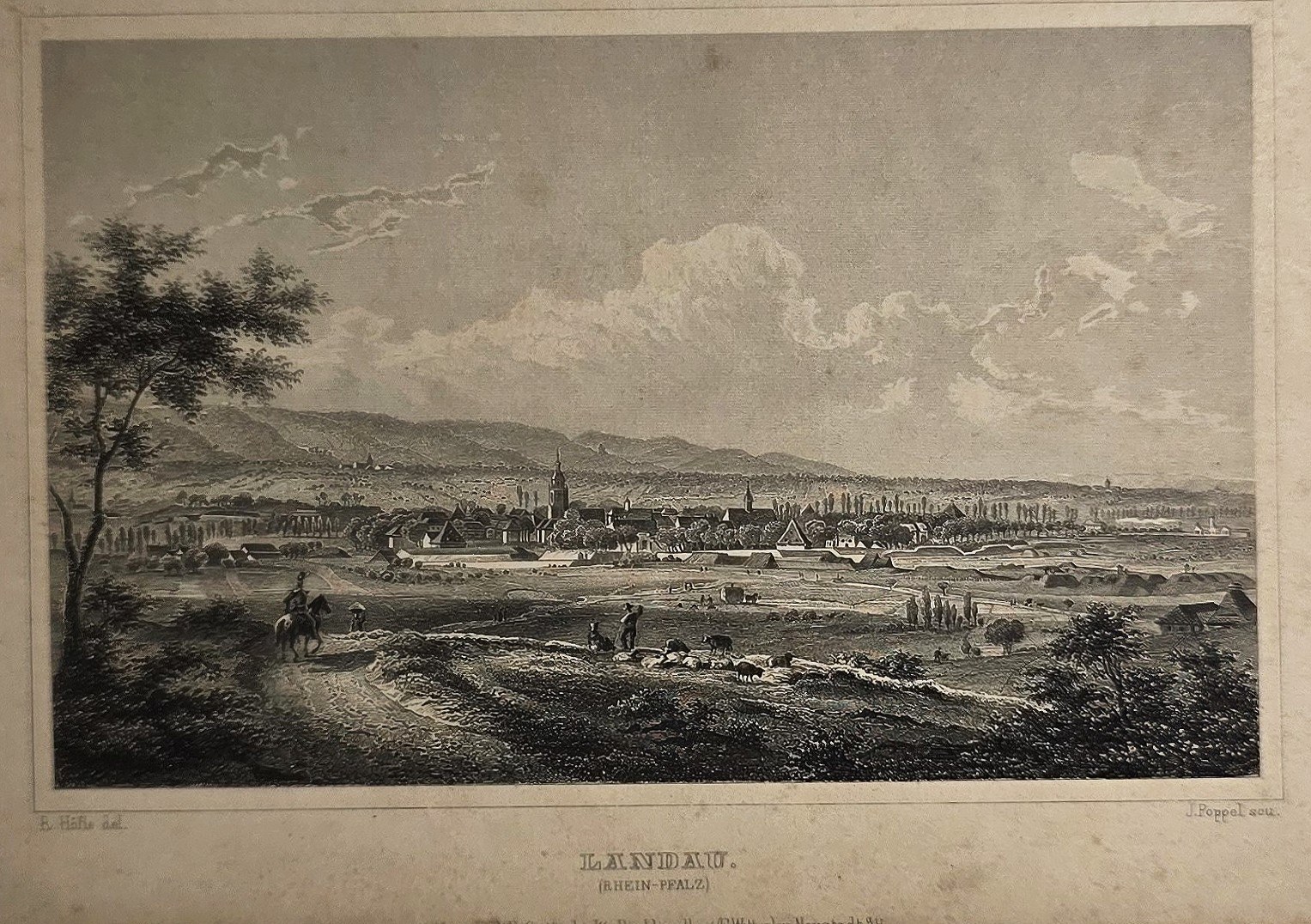 Weite Stadtansicht über Felder und Wege