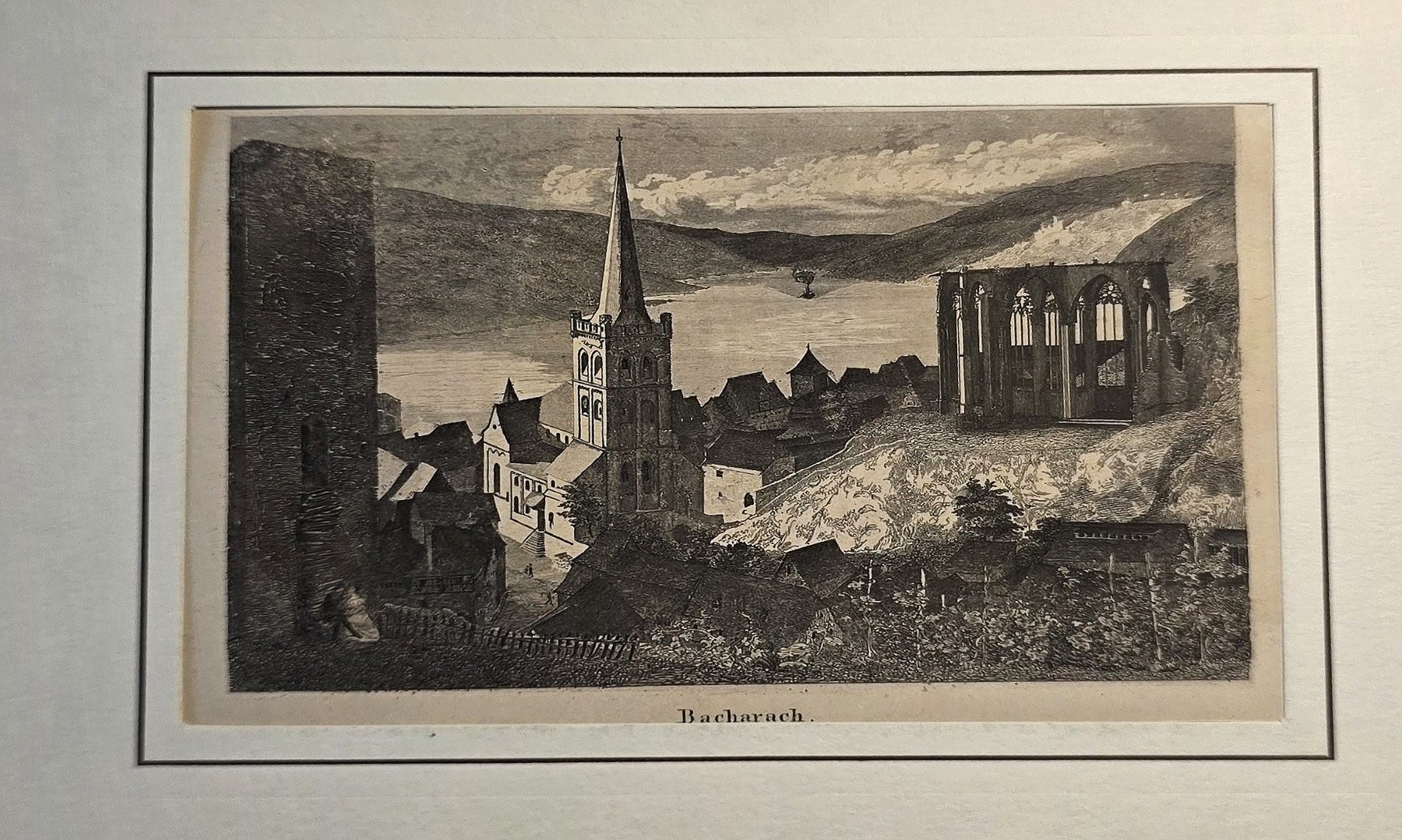 Dorfansicht mit Kirchturm und Ruinenbogen