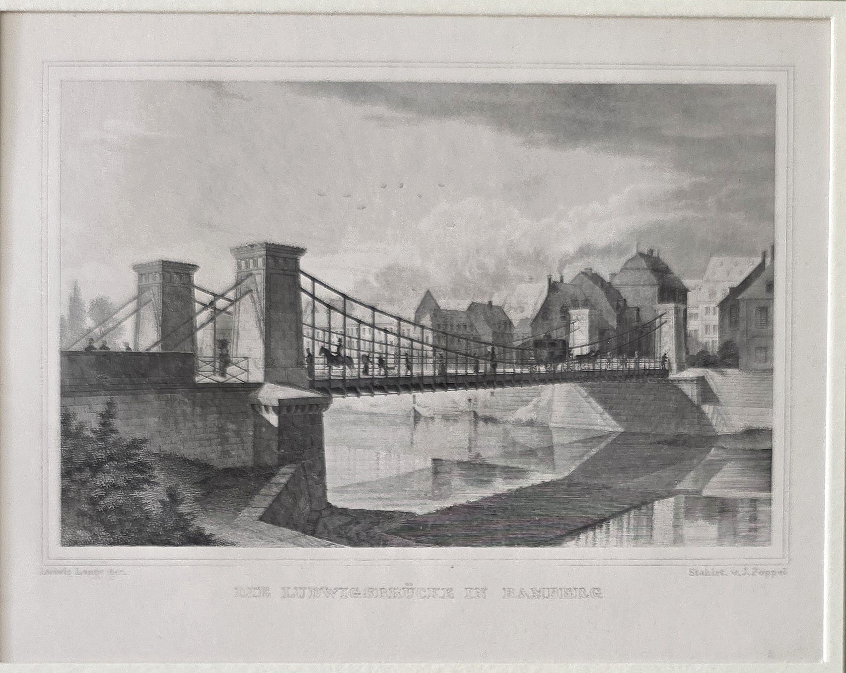 Hängebrücke vor dichter Uferbebauung
